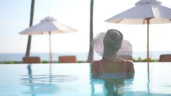 Young asian woman enjoy around outdoor swimming pool for leisure alt