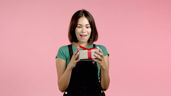 Excited Woman Received Gift Box with Bow. She Is Happy and Flattered By Attention. Girl Smiling with alt