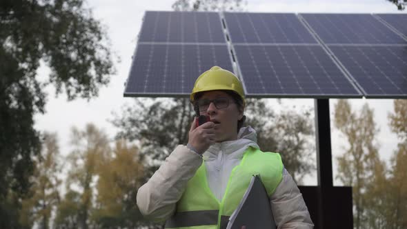 Worker inspects the solar panels and reports the information to the management alt