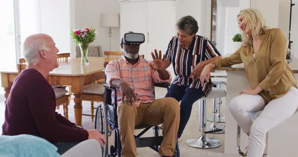 Two diverse senior couples sitting on a couch disabled african american man is using vr googles alt