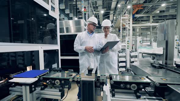 Solar Cells Production Process with Two Experts Observing It alt