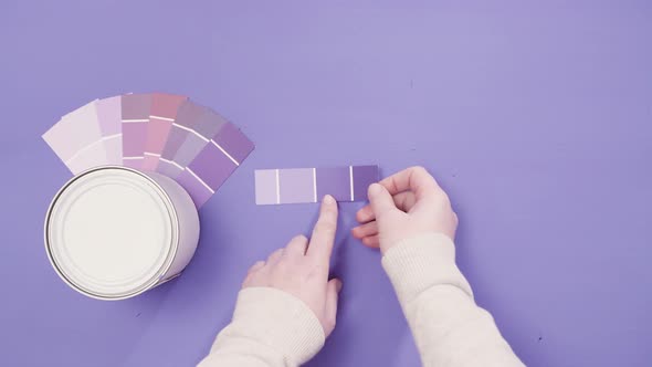Close up of metal paint can with purple paint and paint swatch. alt
