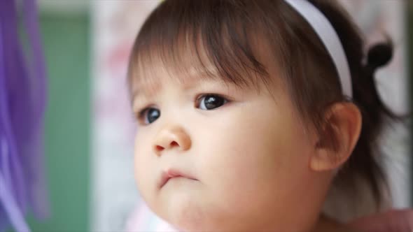 Cute Caucasian Mixed Toddler Baby Infant Girl Looking at Something Curiously alt