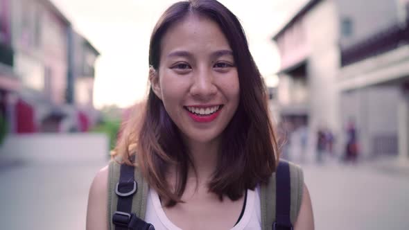 Cheerful young Asian backpacker woman feeling happy smiling to camera while traveling at Chinatown