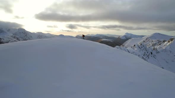 Mountain Climber Reaching the Summit of a Snowy Mountain alt