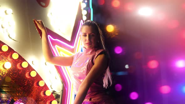 Beautiful Woman With Blond Ponytail Dancing By Neon alt