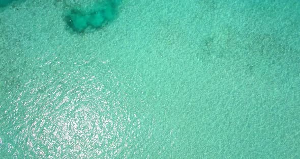 Aerial drone view of a woman floating and swimming on a tropical island alt