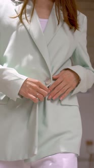 a shy young businesswoman pulls up her jacket as she leaves building alt