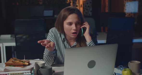 Dissapointed Female Office Worker Talking on Phone with Her Boss , Telling Her To Finish Lot of Work alt