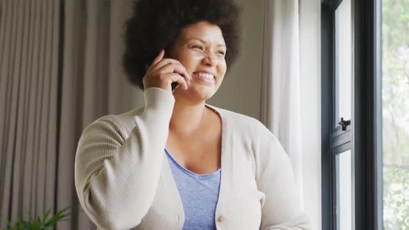 Video of happy plus size african american woman using smartphone alt