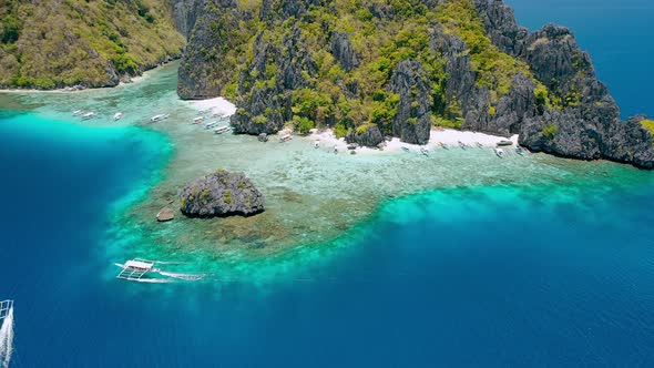 Aerial Drone Footage of Tourist Banca Boat Approaching Shimizu Island Beach in El Nido Palawan alt