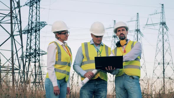 Energy Workers Are Planning a Project Near Electrical Towers, Enenrgy Engineers Inspecting a Power alt