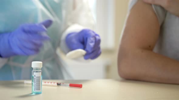 Nurse Wearing Goggles Mask Disposable Gloves Injects Vaccine Into Patient's Shoulder alt