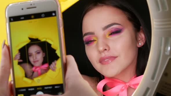 A Beautiful Young Girl Model with a Bright Juicy Yellow Fashion Makeup and a Pink Bow Around Her alt