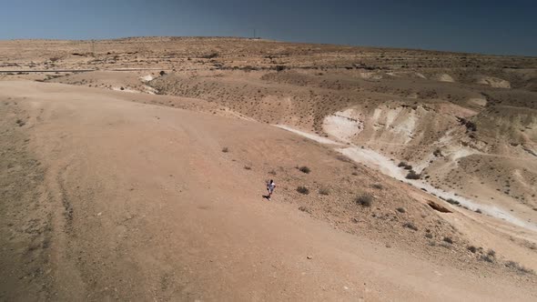 View From Above Stunning Aerial View of an Unidentified Person Walking on a Deserted Desert Road