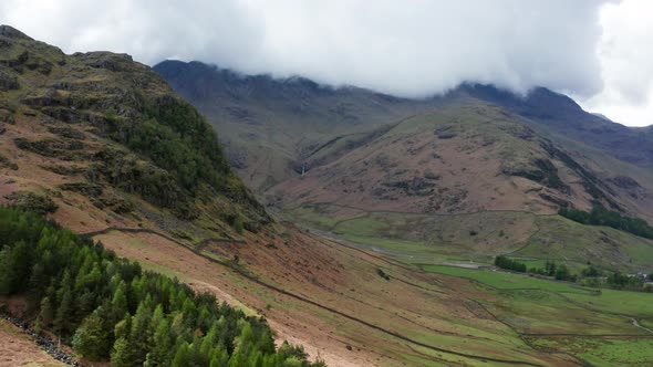 Aerial View Over Hills Towards Mountains