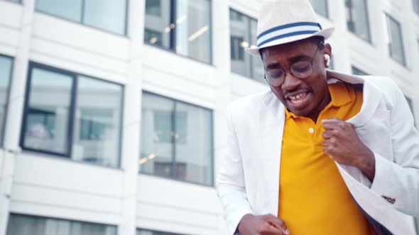 African American man in headphones and glasses dances alt