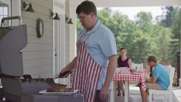 Man cooking with grill at backyard barbeque