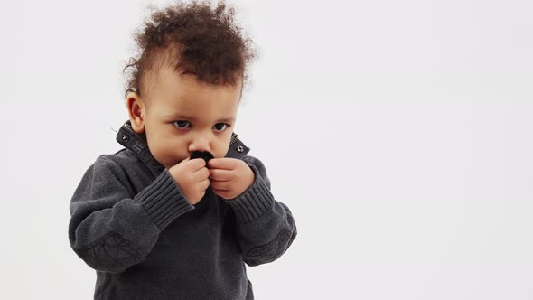 Afro American Curlyhaired Boy Sticks Fake Moustache to His Face Medium Closeup Copy Space Movember alt