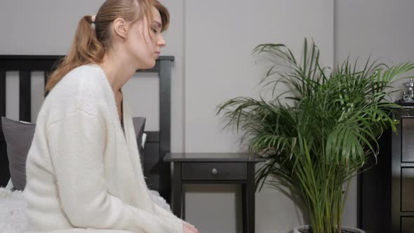 Upset Sad Woman Sitting on Side of Bed alt