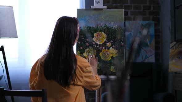 Female Artist Applying Final Touches To Painting alt