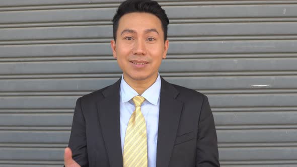 Asian smiling businessman explaining work to customer