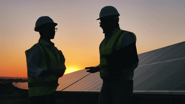 Power Specialists Are Having a Conversation Beside the Solar Panels. Energy Efficiency, Energy alt