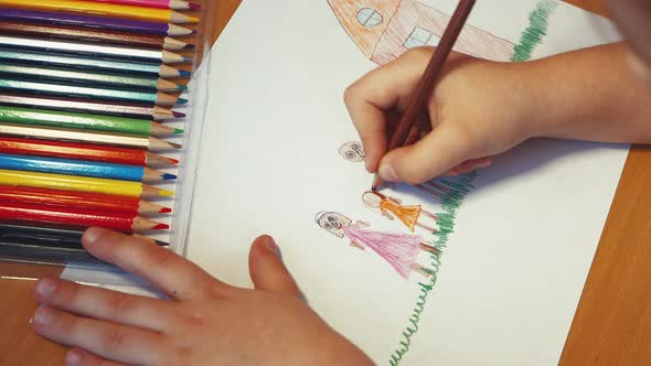 Children's Hands Draw Mom Dad and Daughter Near the House with a Pencil alt