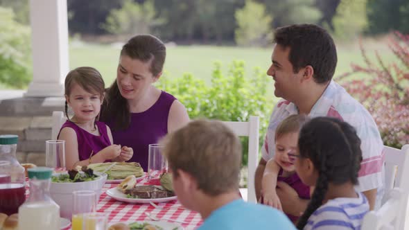 Group of people eating and enjoying a backyard barbeque