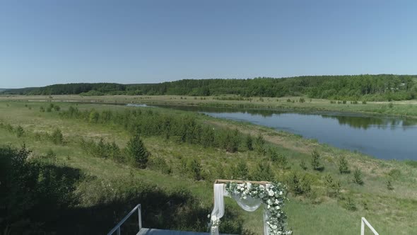 Aerial view of wedding arch on the pier by the river next to the forest 11 alt