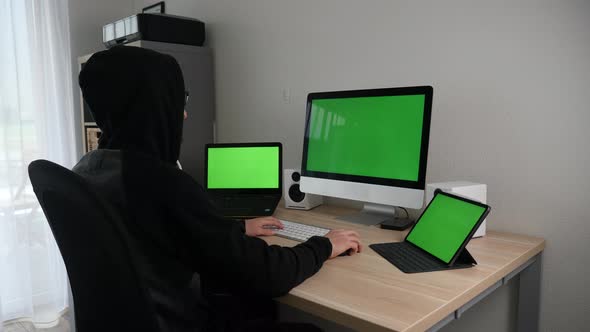 Hacker programmer working tirelessly on green screens alt
