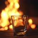 Empty glass for whiskey or brandy is amid the burning flames in the fireplace. - VideoHive Item for Sale