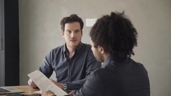 Man reviewing document and listening to explanation