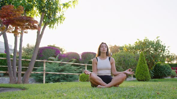 Wide shot of a young woman doing yoga and mindfulness in a garden alt