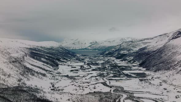 Aerial drone shot overlooking the mountains, the ocean, and the fiords of Kaafjord in Manndalen Nort alt