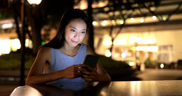 Woman using mobile phone at night  alt