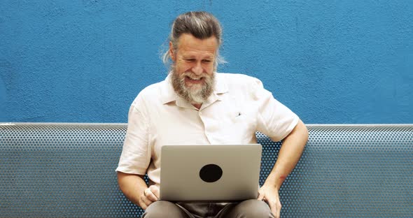 Fiftyyearold Man with Gray Hair Making a Video Call on the Street alt