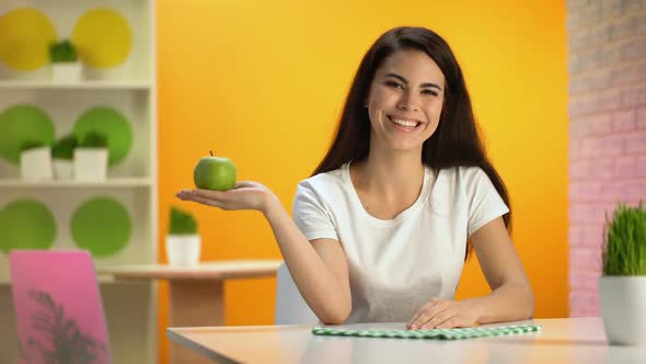 Smiling Beautiful Lady Holding Green Apple Hand Sitting Table, Health Care, Diet alt