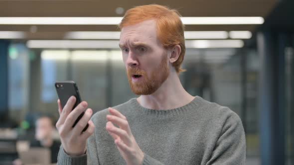 Portrait of Young Man Reacting to Loss on Smartphone alt