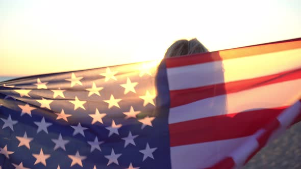 Attractive Young Woman in a Swimsuit on the Sea Beach with the USA Flag alt