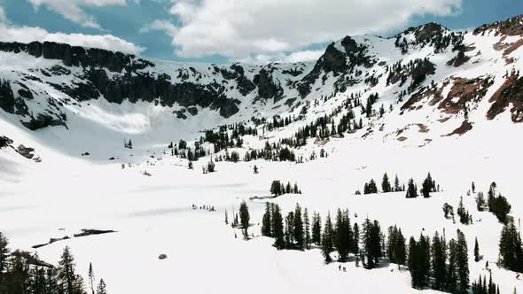 group of people hiking on harsh condition through mountains alt