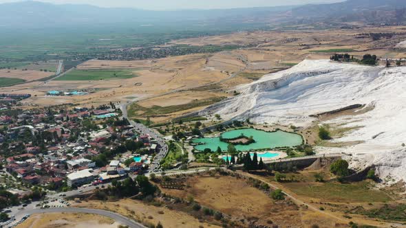 wide aerial view of the world famous Pamukkale thermal pools and green lake surrounded by mineral ri alt