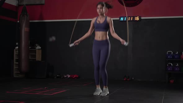 Young athletic woman training with jumping rope, Sportswoman is skipping with jumping rope in gym