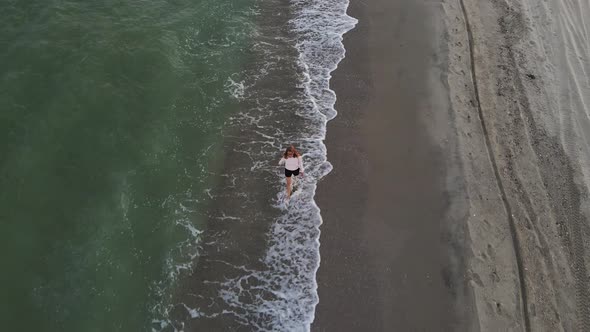 Beautiful Barefoot Woman Walking Along Deserted Beach
