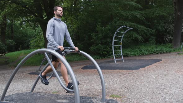 Athlete Exercising On Outdoors Gym Equipment In Forest