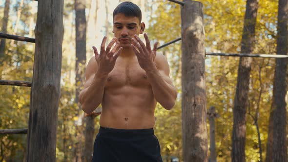 Man shows his hands with bruised calluses in the blood after hard workout.