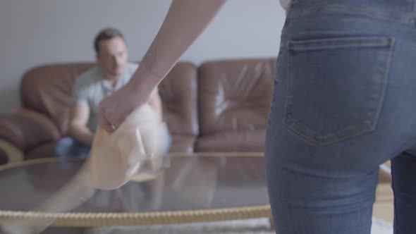 The Young Sad Man Sitting on the Sofa in the Background While Unrecognizable Wife Shouting at Him alt