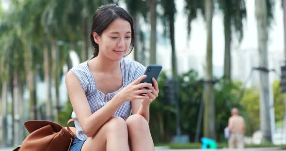 Woman use of mobile phone in city alt