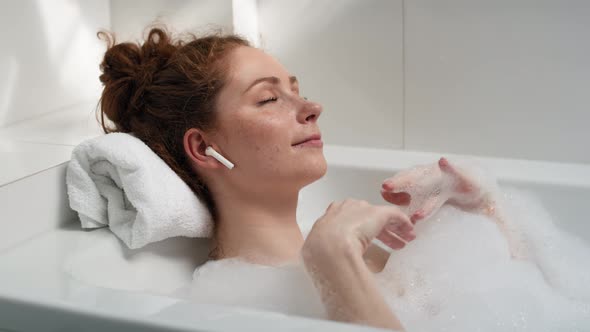 Caucasian woman taking a bath and listening music. Shot with RED helium camera in 4K. alt