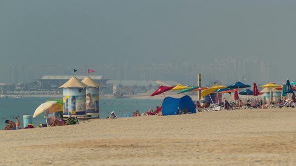 People on the Jumeirah Beach in Dubai UAE alt